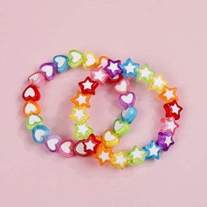 Veelkleurige ster en hart armband met roze achtergrond