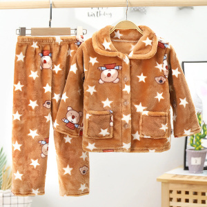 Fleece pyjama met sterren en strepen voor kinderen in bruin en wit met patronen in een slaapkamer met een plant erachter