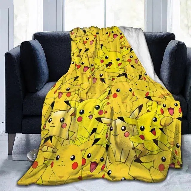 Pokémon-deken met Pikachu-motief voor kinderen op een zwarte bank voor een raam