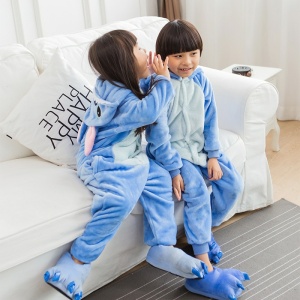 Blauw gestikte warme cartoon pyjama voor kinderen met 2 kinderen op een witte bank