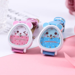horloge voor meisjes, twee kleuren van hetzelfde model worden samen gepresenteerd, een roze en de andere blauw, ze staan op een roze steun, de wijzerplaat stelt het hoofd van een teddybeer voor