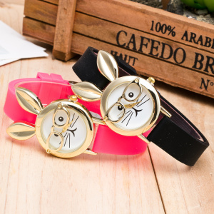 op een houten tafel, twee horloges van hetzelfde model, bij een houten kast, een roze en een zwart, met een schattig konijntje met bril op de wijzerplaat