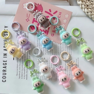 10 mini sleutelhangers met Labubu-knuffels rechtop met gekleurde ringen, in 10 verschillende pasteltinten, liggend op een open tijdschrift.