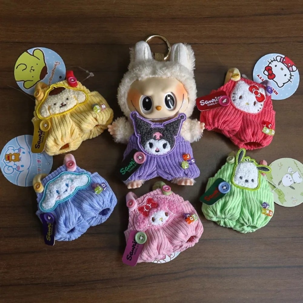 Kleurige miniatuurkleding voor Labubu-knuffel, geborduurd met Hello Kitty-motieven, liggend op een houten tafel.