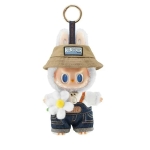 Witte Labubu-knuffel met beige hoed, jeans tuinbroek en witte bloem.